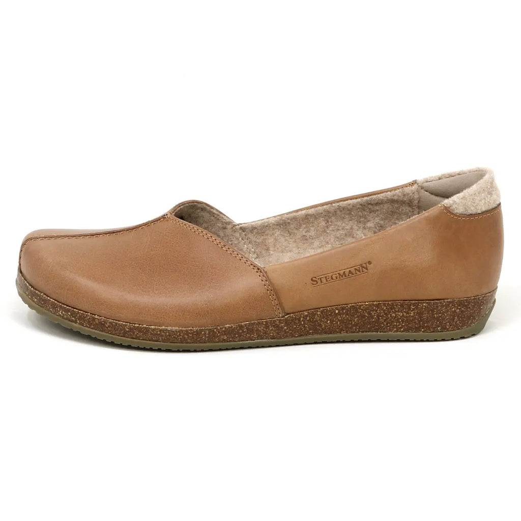 Women's Liesl Leather Skimmer: Durable brown slip-on shoes featuring a minimalist design with anatomically shaped support for ultimate comfort and a sturdy cork sole. Stegmann brand logo visible on the side.