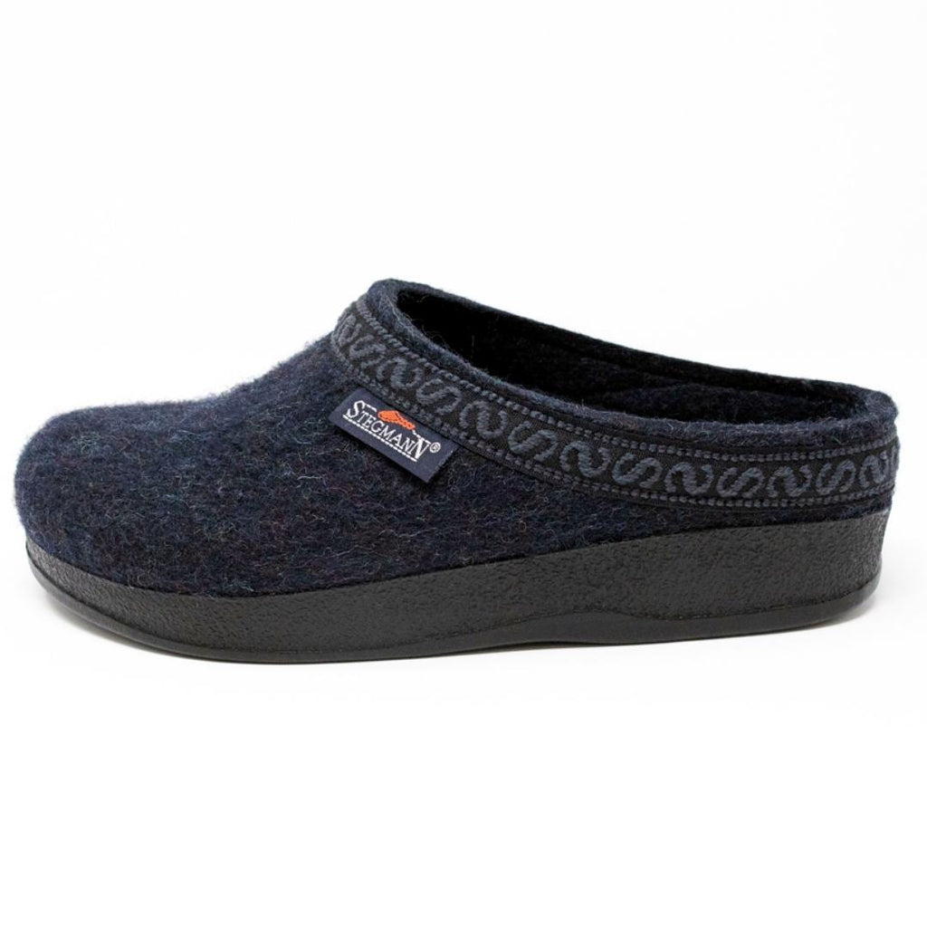 The Women's WoolFlex Clog - Medium features a dark blue felt design with a Merino wool upper, a black supportive sole, and decorative trim, all showcased on a white background.